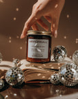 Hand reaching for a jar labeled 'Mirrorball' surrounded by disco balls on an open book.