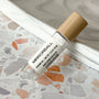 perfume roller labeled Mirrorball on a terrazzo surface