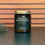 Jar of 'Oregon Evergreen' candle with a gold lid on a wooden surface
