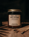 Jar labeled 'Relax + Release' on a wooden surface with a dark background