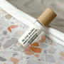 perfume roller labeled Slow Burn on a terrazzo surface