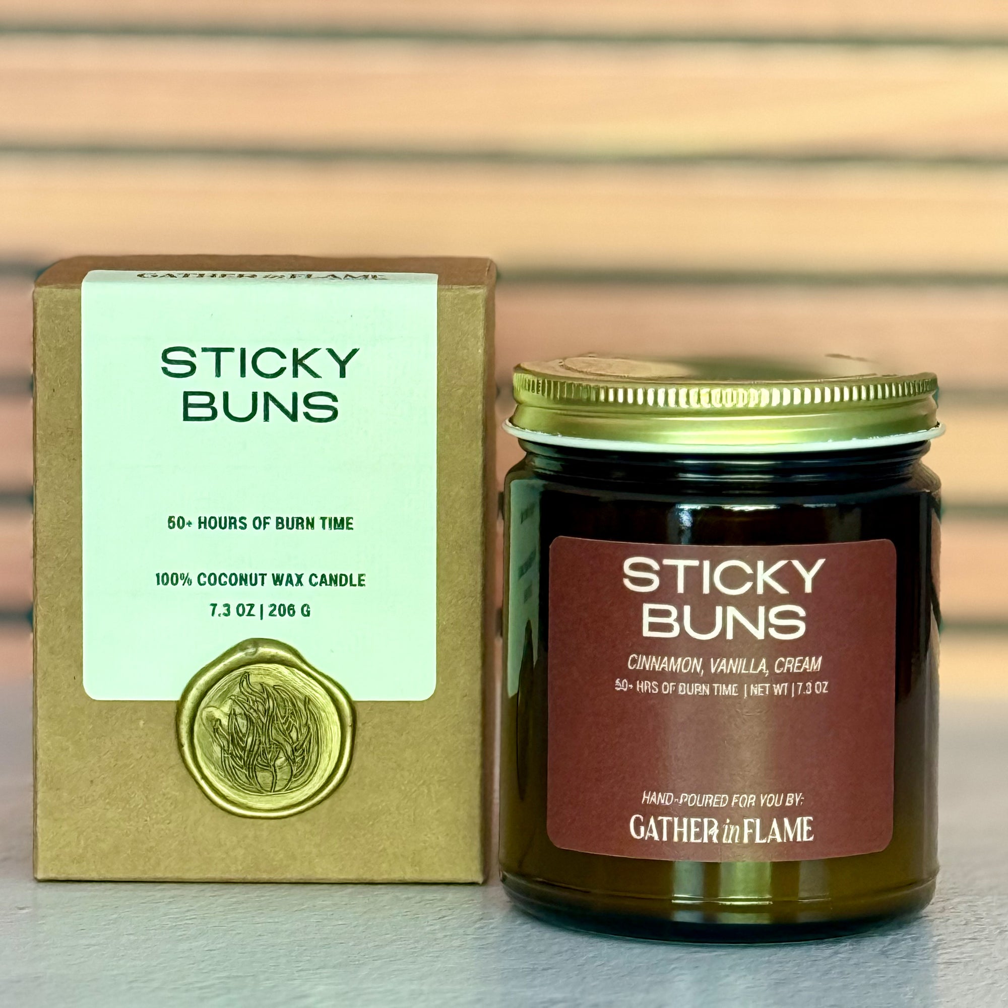 Sticky Buns candle and packaging with 'Gather by Flame' branding on a neutral background