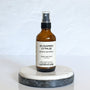 A brown amber spray bottle labeled 'Sugared Citrus' by Gather In Flame Candle Co. on a white marble surface.