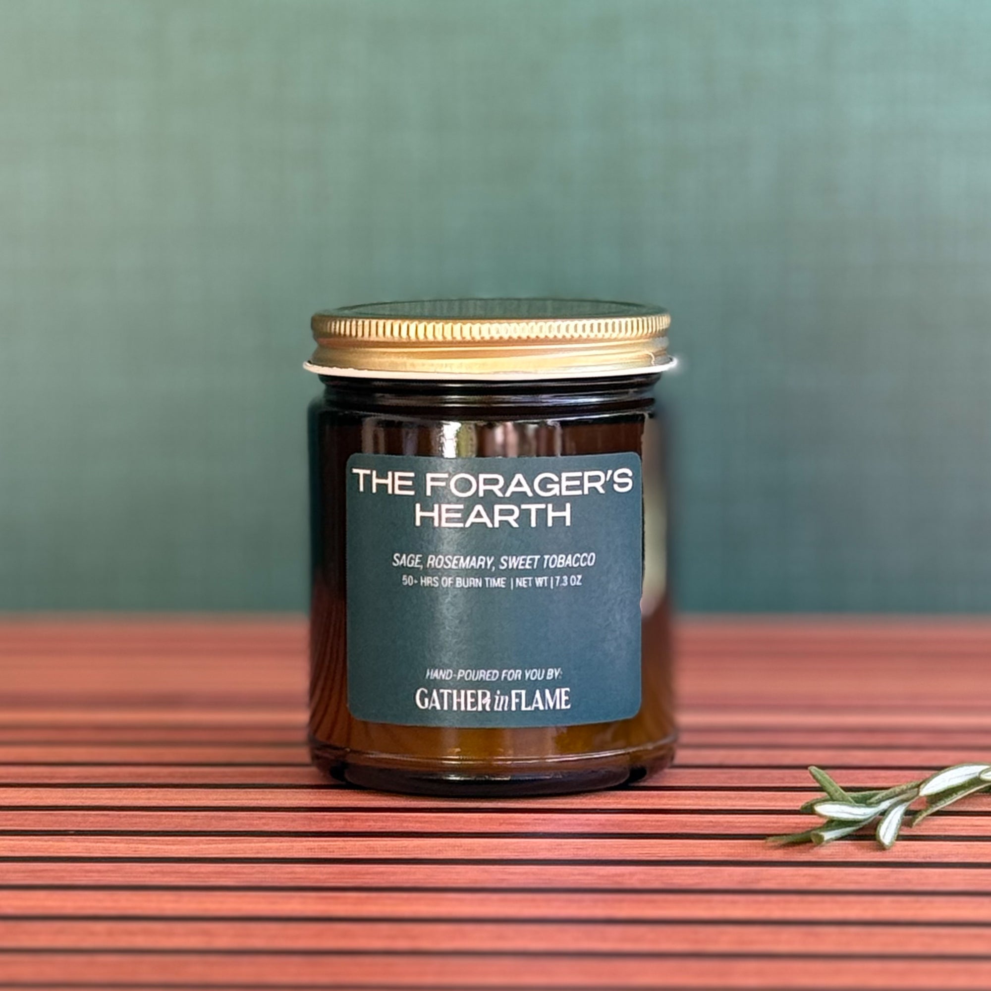 Candle labeled The Forager's Hearth on wooden background
