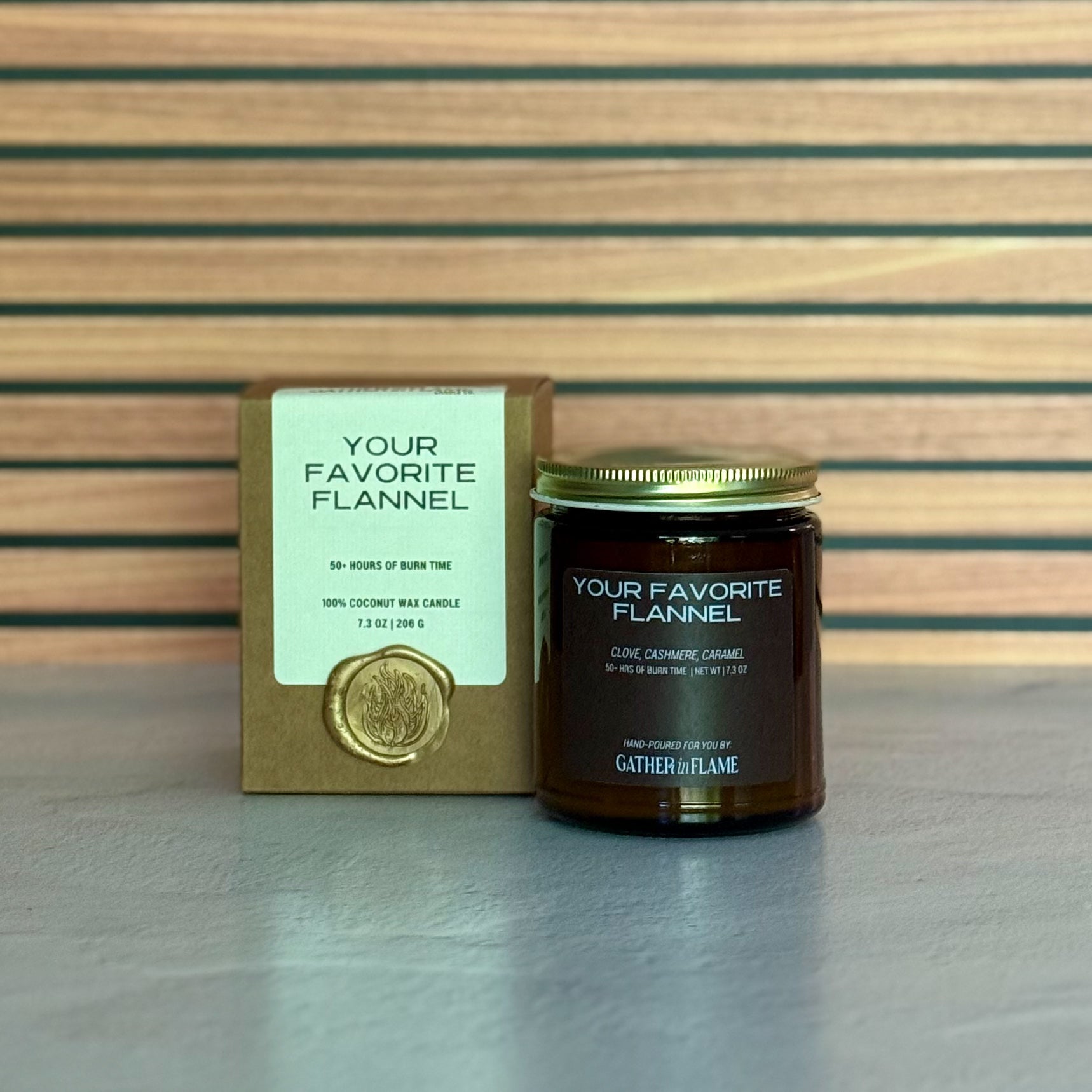 Candle labeled 'Your Favorite Flannel' with packaging on a striped background