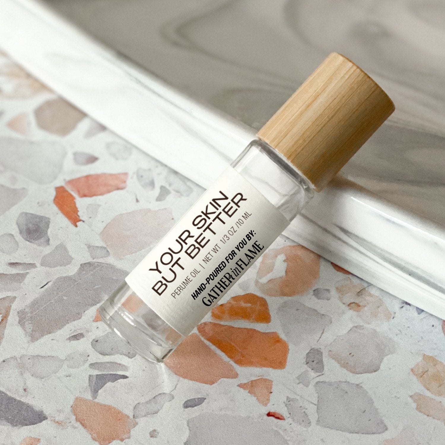 perfume roller labeled Your Skin But Better on a terrazzo surface